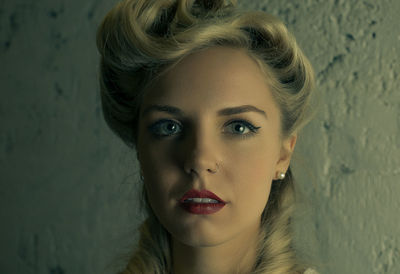 Close-up portrait of beautiful young woman against wall