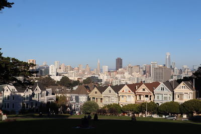 Buildings in city against clear blue sky