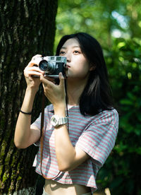 Young woman photographing with camera