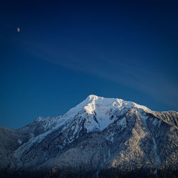 Scenic view of snowcapped mountains against clear blue sky