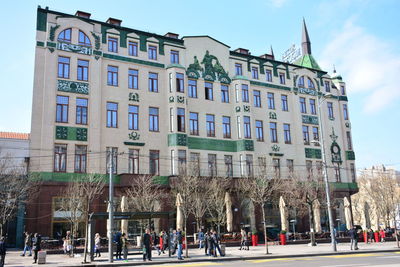 People in front of building against sky