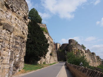 Road by wall against sky