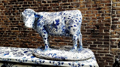 View of animal statue against brick wall