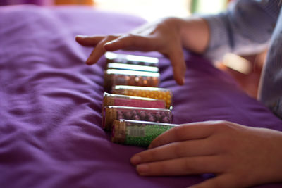 Midsection of baby playing with containers on bed at home