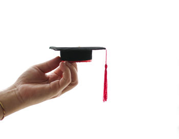 Close-up of hand holding eyeglasses against white background