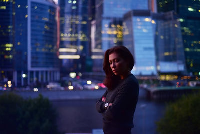 Side view of woman in city at night