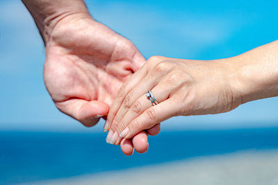 Midsection of couple holding hands