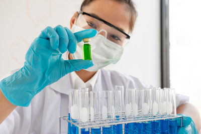 Close-up of scientist holding vial in laboratory