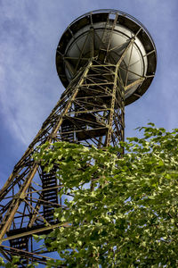 Low angle view of metallic water tower against sky