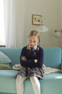 Angry girl sitting on sofa