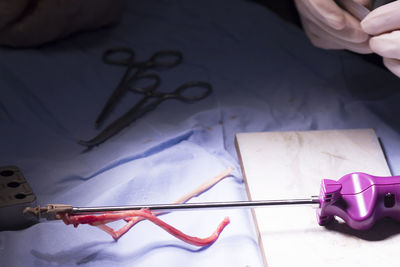 Cropped hand of doctor by medical equipment on table