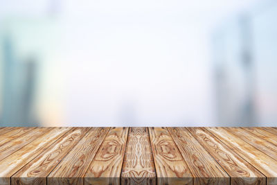 Close-up of wooden table against wall