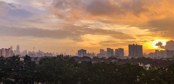 View of cityscape against cloudy sky during sunset