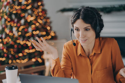 Cheerful businesswoman talking on laptop at office