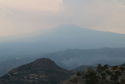 Scenic view of mountains against cloudy sky