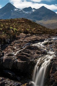 Scenic view of waterfall against sky