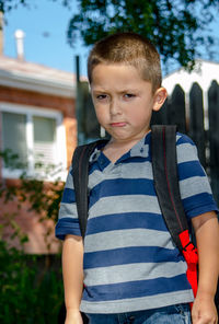 Pouting boy with back pack, not happy to go back to school