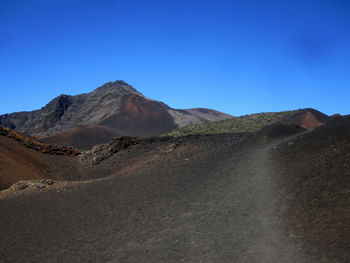 Scenic view of volcanic landscape against clear blue sky