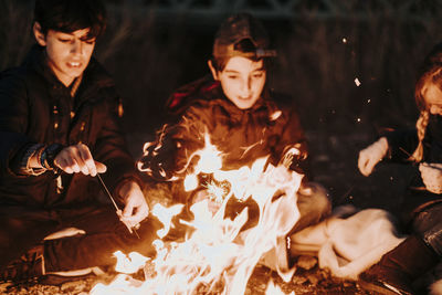 Group of young friends camping and burning a wood fire