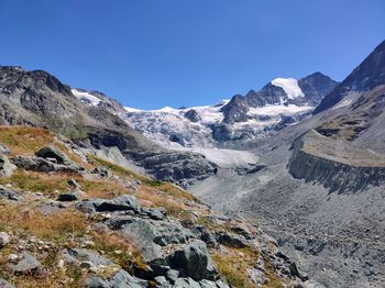 Scenic view of snowcapped mountains against clear blue sky