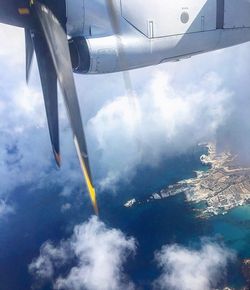 Airplane wing against cloudy sky