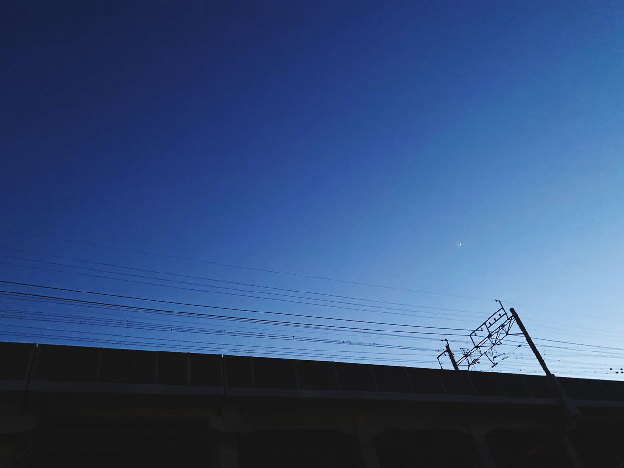 LOW ANGLE VIEW OF CABLES AGAINST CLEAR BLUE SKY