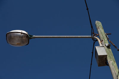 Low angle view of street light against blue sky