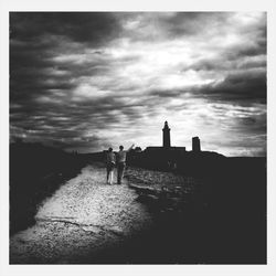 Silhouette of people against cloudy sky