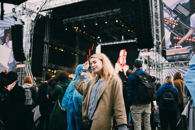 Woman with eyes closed standing at music concert