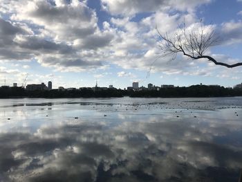 Scenic view of river by buildings against sky