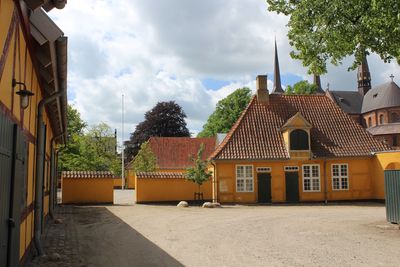 Houses by street and buildings against sky