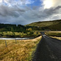 Empty road along countryside landscape