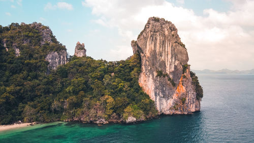 Aerial view of rock formations by sea against sky