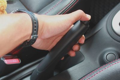 Cropped hand holding gearshift in car