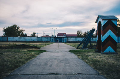 Empty road by building against sky