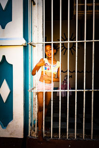 Full length of woman sitting on metal window