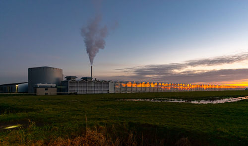 Modern greenhouse is being heated by gas and illuminated by the twilight sky on a winter evening.