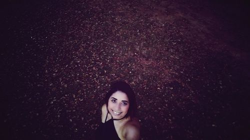 High angle view of smiling young woman standing on field