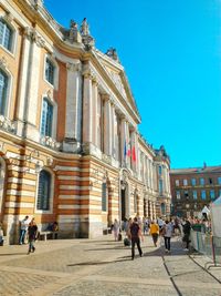 People walking in front of historical building