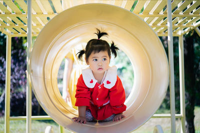 Cute girl looking away while playing at playground