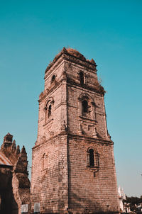 Low angle view of old building against blue sky