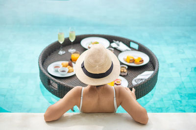 High angle view of woman relaxing in swimming pool