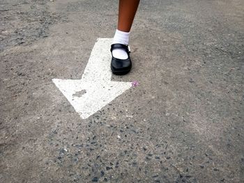 Low section of woman standing on road