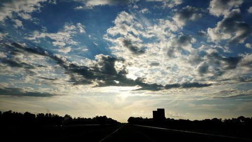 Country road against cloudy sky