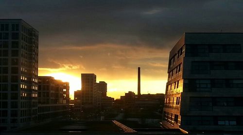 Buildings against cloudy sky at sunset