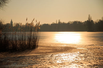 Scenic view of lake against sky at sunset