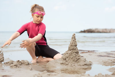 Full length of boy on beach against sky