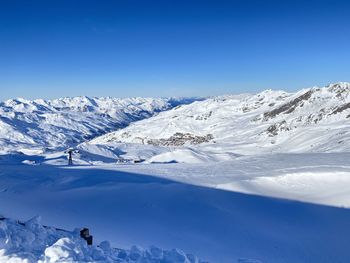 Snow covered mountains against blue sky