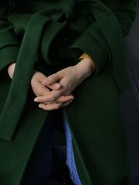 Close-up midsection of woman with hands clasped