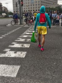 Rear view of people walking on street